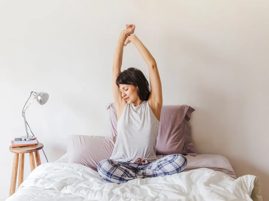 سيدة تقوم بحركات تمدّد بسيطة قبل النوم  Image By Freepik