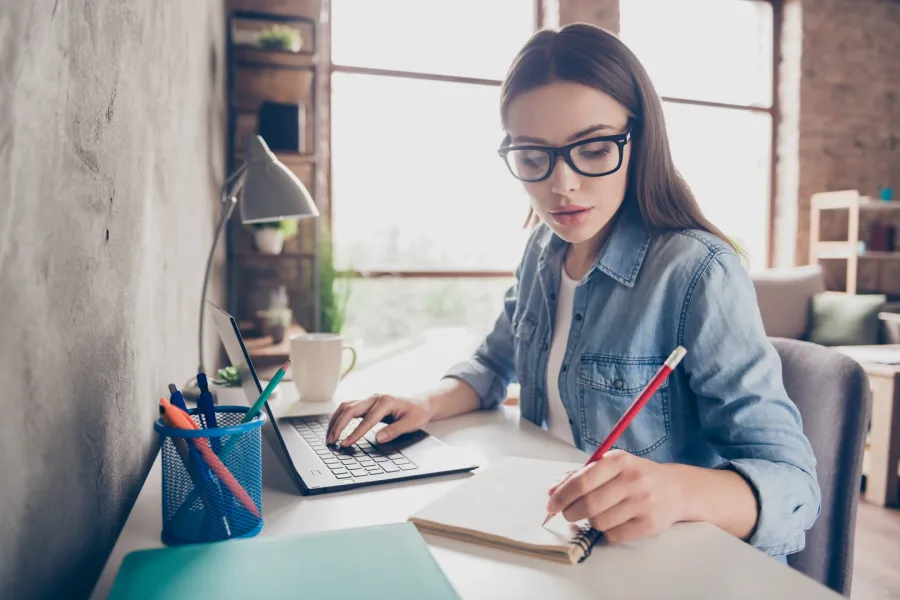 شابة يبدو عليها ملامح الجدية وهي تجتهد في عملها على جهازها المحمول