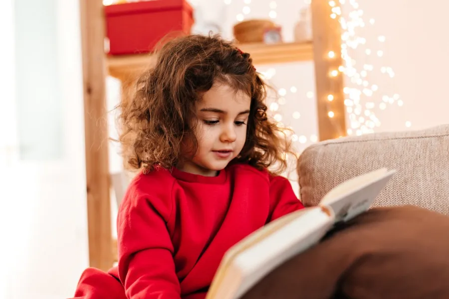 صورة لطفلة تمسك بالكتاب