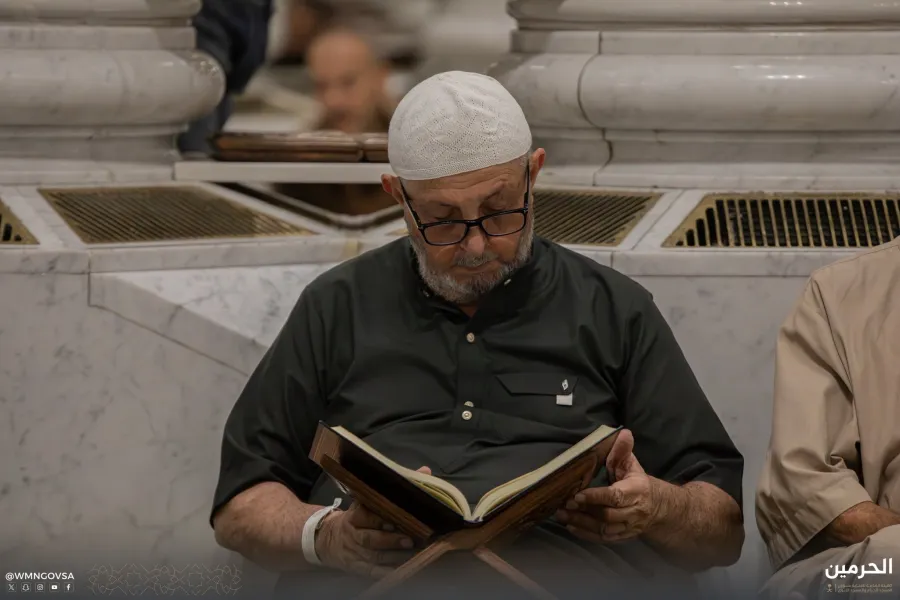 معتمر يجلس داخل المسجد النبوي يقرأ القرآن - الصورة من حساب الهيئة العامة للعناية بشؤون الحرمين المسجد النبوي على منصة إكس