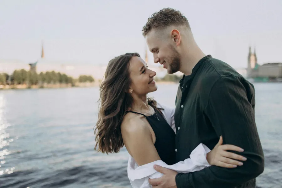 زوج يحتضن كتف زوجته ويمسك يدها وهي يبدو عليها الشعور بالسعادة والأمان