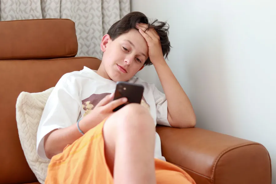 صورة مراهق مدمن على الهاتف