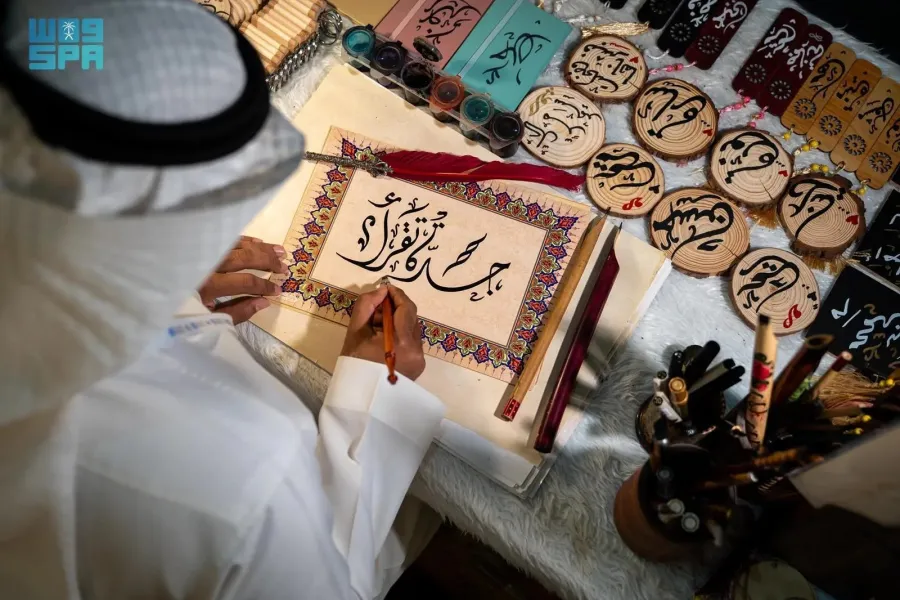 خطاط سعودي يرسم شعار معرض جدة للكتاب "جدة تقرأ" - الصورة من وكالة الأنباء السعودية "واس"
