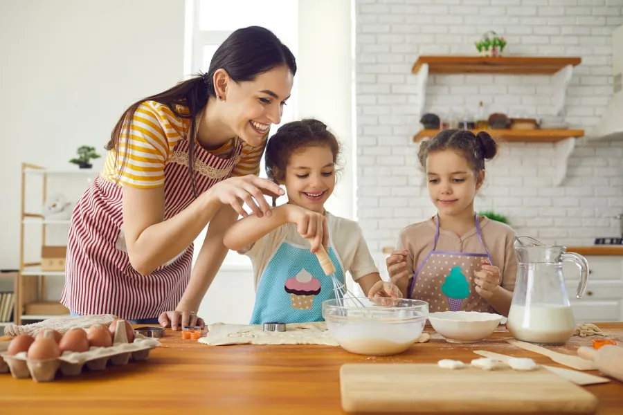 صورة لأم وطفلتيها بالمطبخ