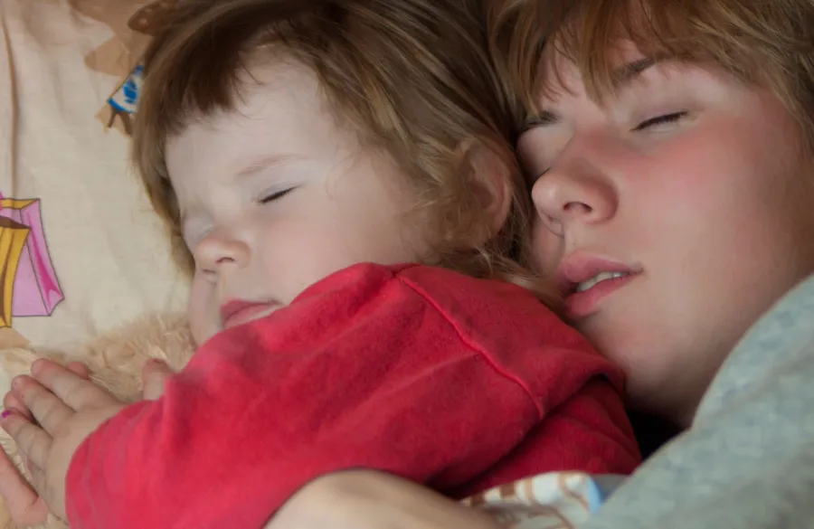 صورة طفل ينام بجانب أمه