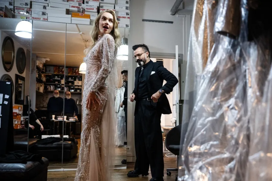 المصمم جوليان فورنييه  Julien Fournie والتعديلات الأخيرة على ثوب العارضة ميكاييلا تومانوفا -مصدر الصورة JULIEN DE ROSA / AFP