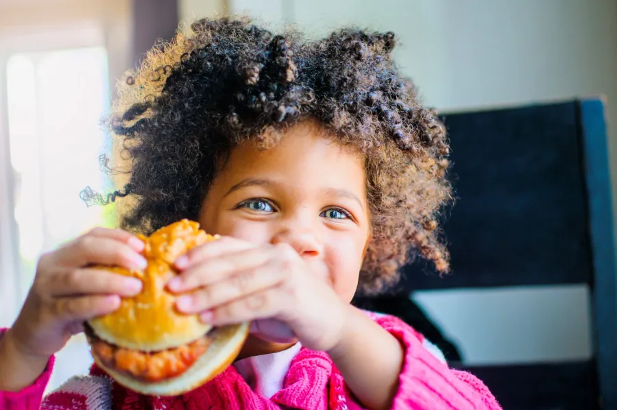 صورة طفل يأكل الوجبات السريعة